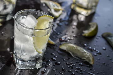 Close up Vodka with ice on a black background, bokeh, reflection, luxury.