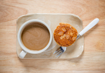 Table Top View of Hot Coffee and Coffee Almond Cup Cake on Woode