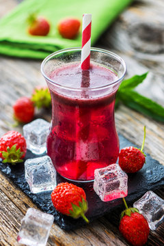 Fresh strawberry juice on wooden background