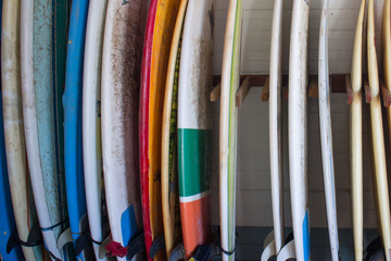 Set of different color surf boards in a stack