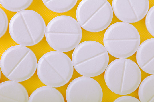 Medical pills on yellow baclground