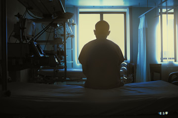 Figure of sitting patient on a hospital bed on the background of