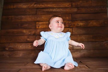 Cute little girl crying on a wooden background.