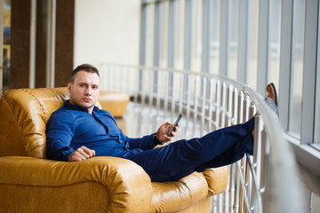 Businessman use of mobile phone and sitting in chair.