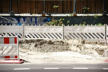 Straßenbaustelle / Eine Baustelle mit Baumaterial und einer Straßenabsperrung.