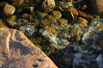 Stones in stream./Stones in stream with smooth flowing water.