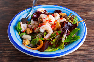 Mussel, shrimp and lettuce Asian style salad with sprinkle of chili