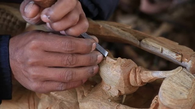 Burmese man are making wooden souvenirs for tourists. Wood Carving is a traditional handicraft in Myanmar