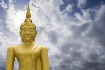 Fototapeta na wymiar Gold image of Buddha with blue sky and cloud in background, light effect added ,filtered image,copy space , prachuapkhirikhan,thailand