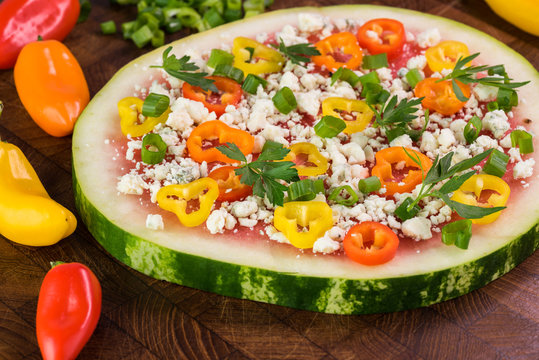 Vegetarian watermelon pizza with crumbled blue cheese, bell peppers and parsley.