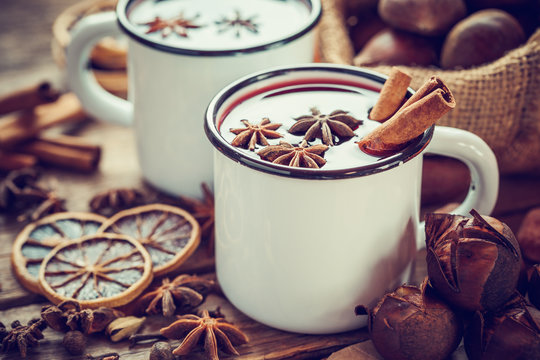 Mulled wine in mugs, dry fruits and roasted chestnuts