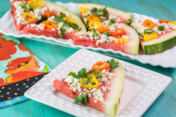Piece of vegetarian watermelon pizza with crumbled blue cheese,