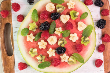Fruit watermelon pizza with fresh berries, banana, kiwi and mint