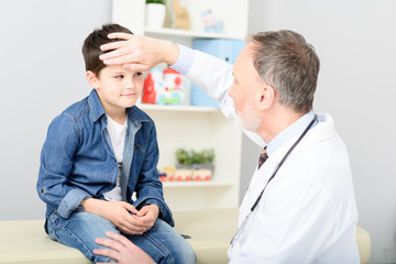 Pediatrician checking temperature of sick patient
