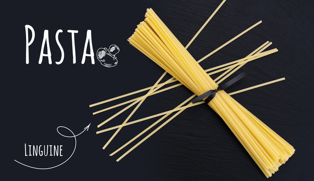 Uncooked Italian Pasta Linguine On Black Slate Stone Background With White Lettering, Top View