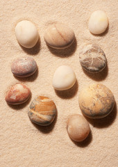 Collection of sea stones on sand. Summer beach background