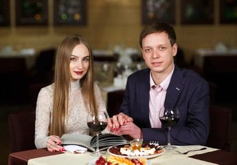 Cheerful couple with menu in a restaurant.