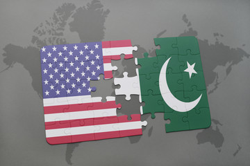 puzzle with the national flag of united states of america and pakistan on a world map background