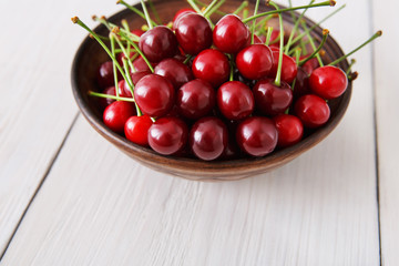 Sweet fresh cherries on white wood background
