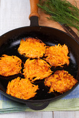 Carrot pancakes in a pan.