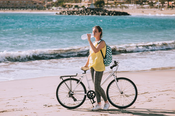 Fototapeta premium carefree woman with bicycle riding on beach sand having fun and