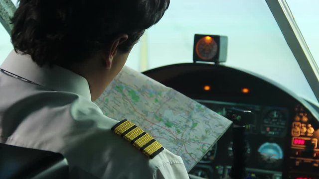 Male co-pilot checking map before operating airliner, responsibility, commitment