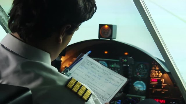 Airplane standing on runway, pilot filling out documents and starting flight