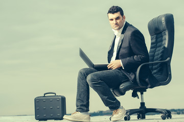 businessman with laptop on chair outdoor