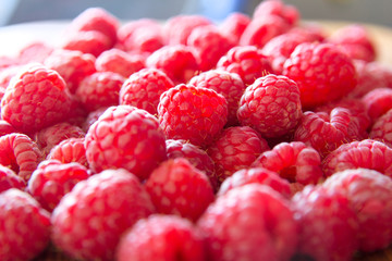 Ripe sweet juicy raspberries on wooden table. Close up, top view