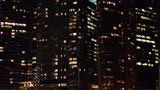 Video 4k - Static shot of several commercial office highrise buildings in the downtown area of a major, metropolitan city at night.