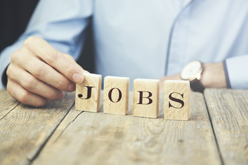businessman holding wooden Jobs