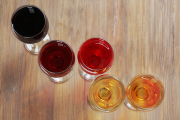 Glasses with wines of different colors on a wooden table