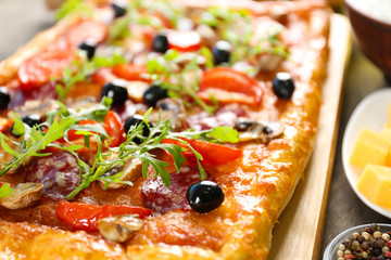 Rectangle delicious pizza and vegetables on the table, close-up