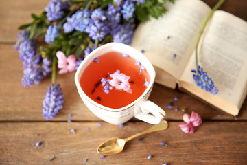 Open book and cup of tea  on wooden table
