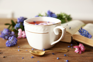 Open book and cup of tea  on wooden table