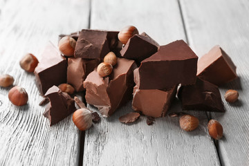 Chocolate pieces with nuts on wooden background