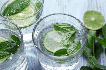 Infused lime water with mint on wooden background