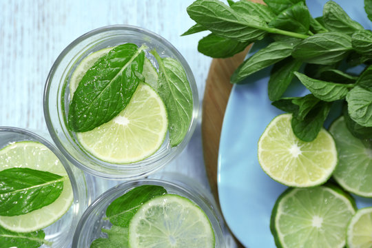 Infused lime water with mint on wooden background