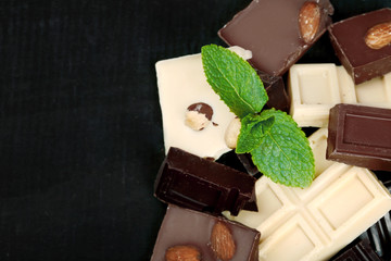 Chocolate pieces with mint leaves on black background