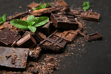 Chocolate pieces with mint leaves on black background