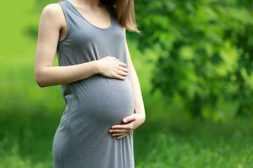 Beautiful pregnant woman in park