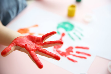 Child making hand prints on paper
