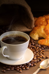 Hot coffee and croissant on wood table