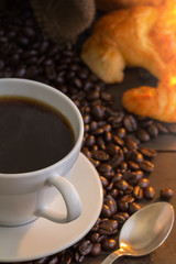 Hot coffee and croissant on wood table