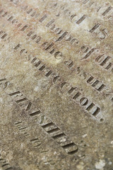 Fototapeta premium Grungy Abstract Hand carved typeset on an old english gravestone, with a shallow depth of field