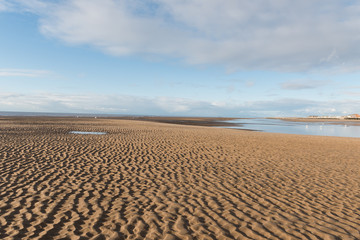 Fototapeta na wymiar Beautiful blue sky and textured sand, on a sunny day at the beach