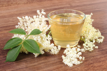 Fresh healthy juice and elderberry flowers on rustic board