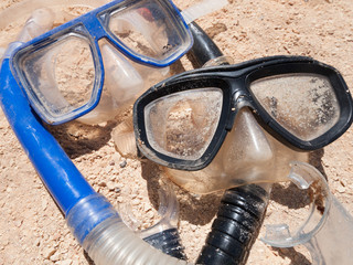 A pair of mask and snorkels on a golden sandy beach, with a beautiful shallow depth of field.