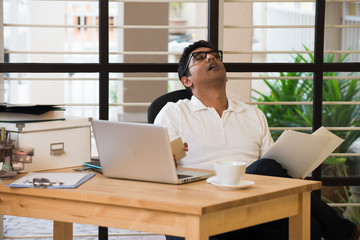 Fototapeta na wymiar sleepy indian man at office