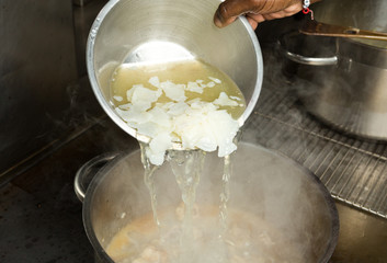 ice Cold fresh organic chicken stock being poured onto hot chicken wings.